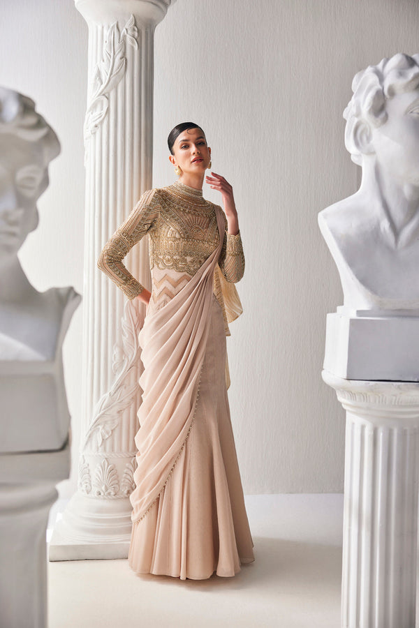 Golden Cream Draped Saree In Luxurious Shimmer Chiffon Offset With A Zardozi Blouse And An Elaborate High Neckline.