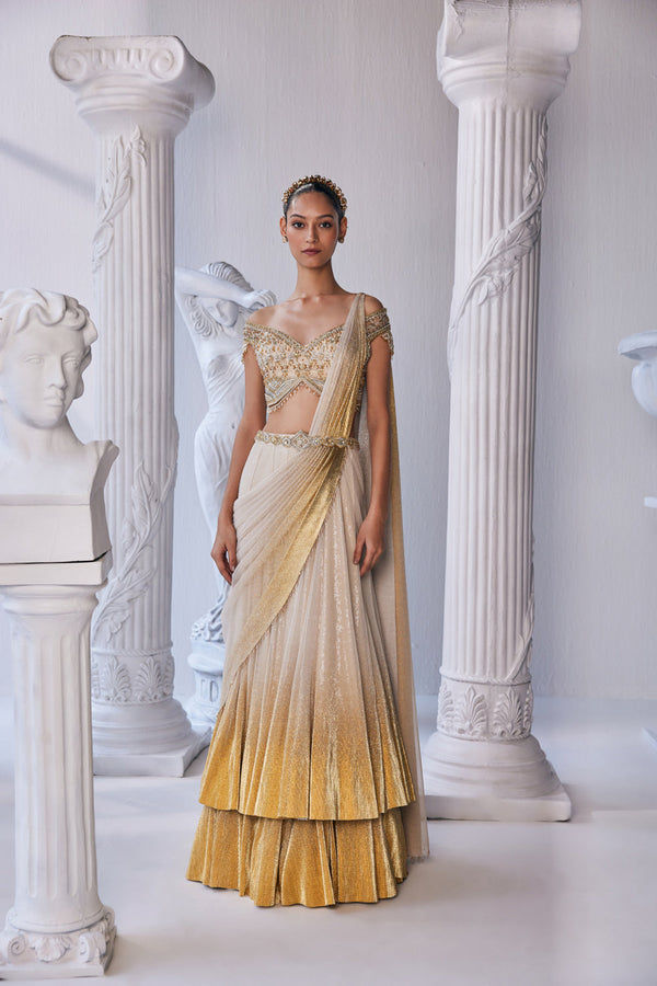 Draped Double Layer Lehenga In Pleated Gold Foil Lycra With An Emroideredwaistband Is Offset With A Corset.