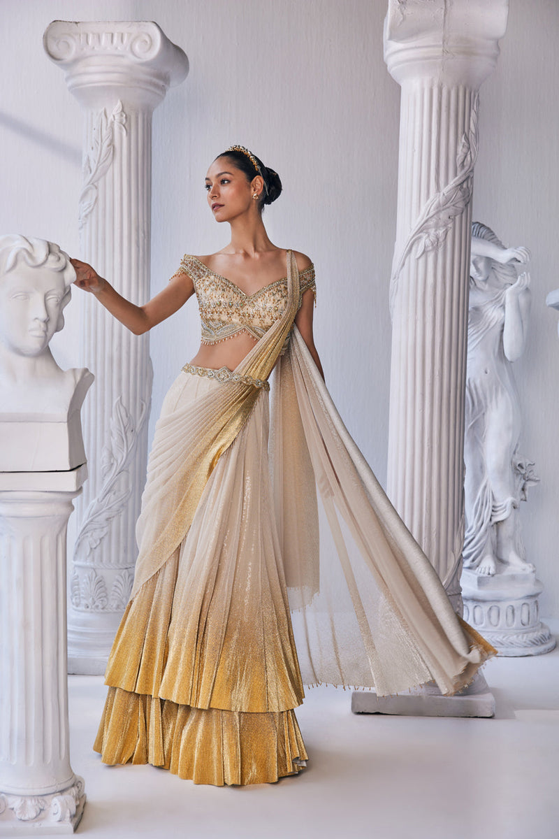 Draped Double Layer Lehenga In Pleated Gold Foil Lycra With An Emroideredwaistband Is Offset With A Corset.