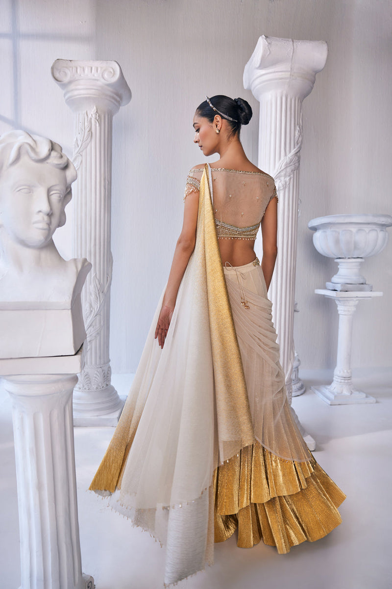 Draped Double Layer Lehenga In Pleated Gold Foil Lycra With An Emroideredwaistband Is Offset With A Corset.