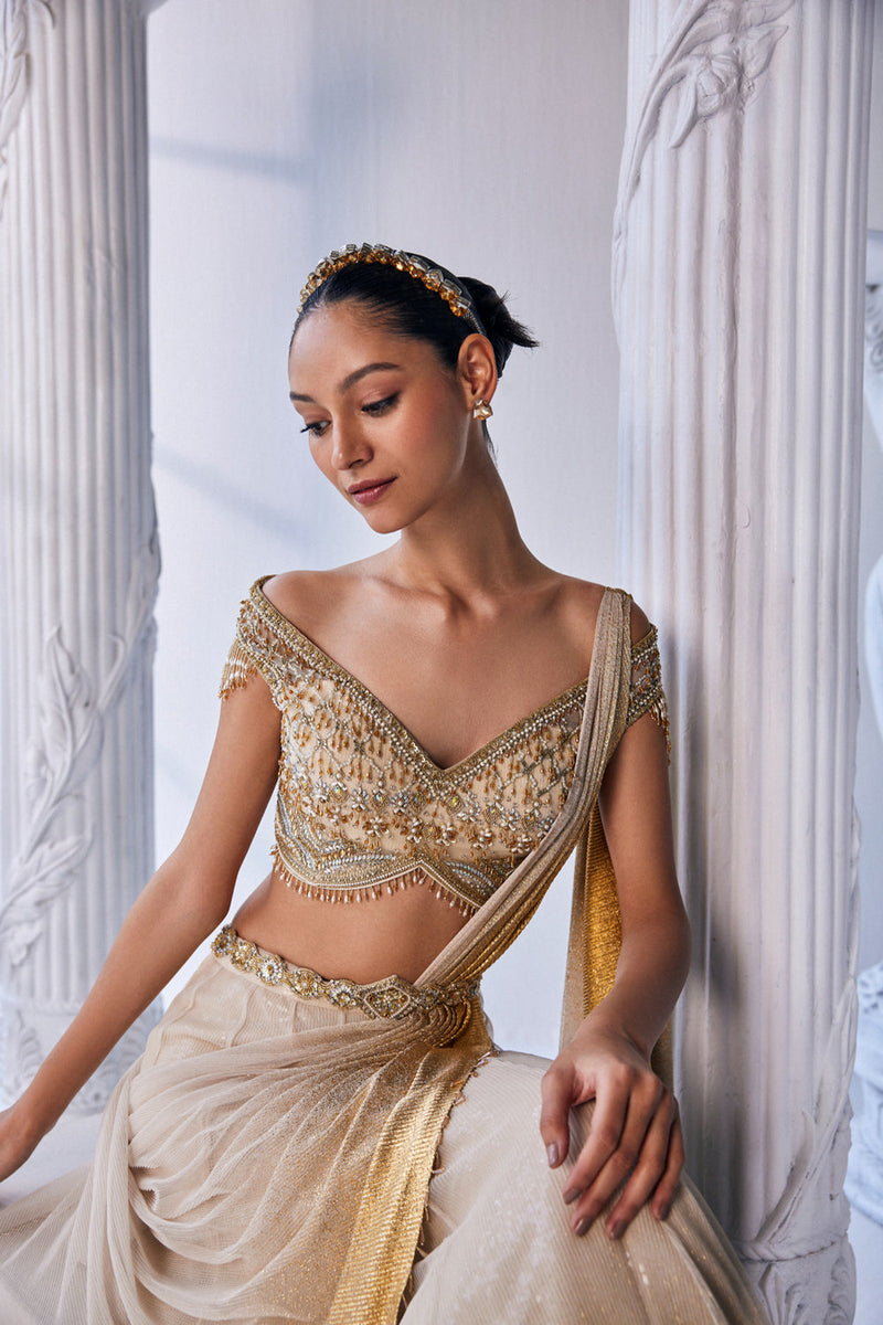 Draped Double Layer Lehenga In Pleated Gold Foil Lycra With An Emroideredwaistband Is Offset With A Corset.