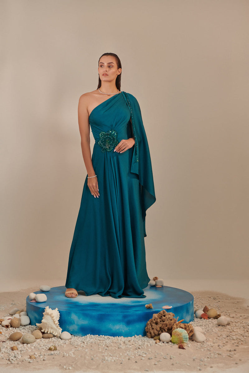 Teal One Shoulder Drape Gown ; Hand Embroidered 3D Shells At Waist, 3 Hand Embroidered Chains At The Sleeve; Asymmetric Open Drape  Sleeve