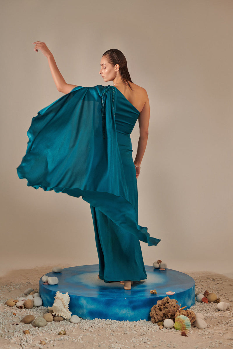 Teal One Shoulder Drape Gown ; Hand Embroidered 3D Shells At Waist, 3 Hand Embroidered Chains At The Sleeve; Asymmetric Open Drape  Sleeve