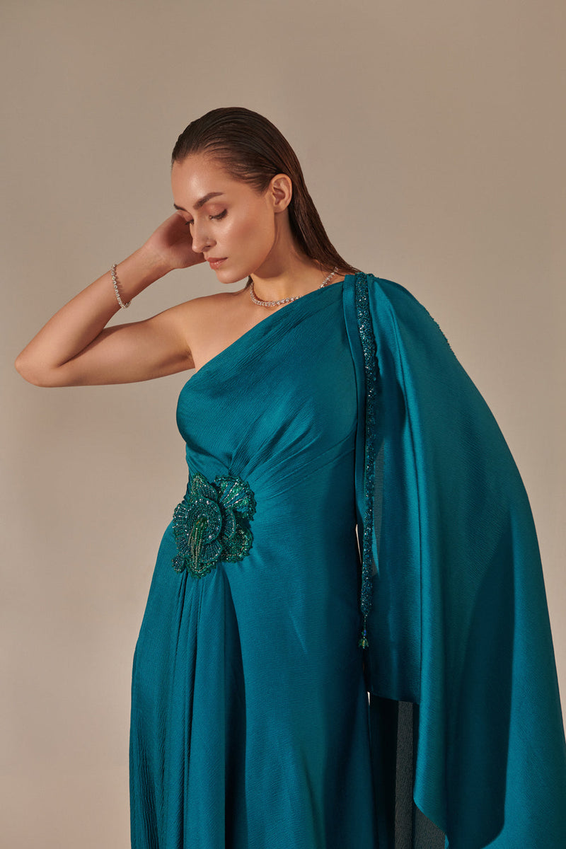 Teal One Shoulder Drape Gown ; Hand Embroidered 3D Shells At Waist, 3 Hand Embroidered Chains At The Sleeve; Asymmetric Open Drape  Sleeve